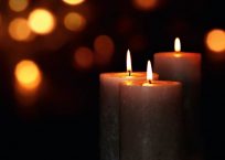 Candle lights in darkness with golden light effects and bokeh for solemn moments